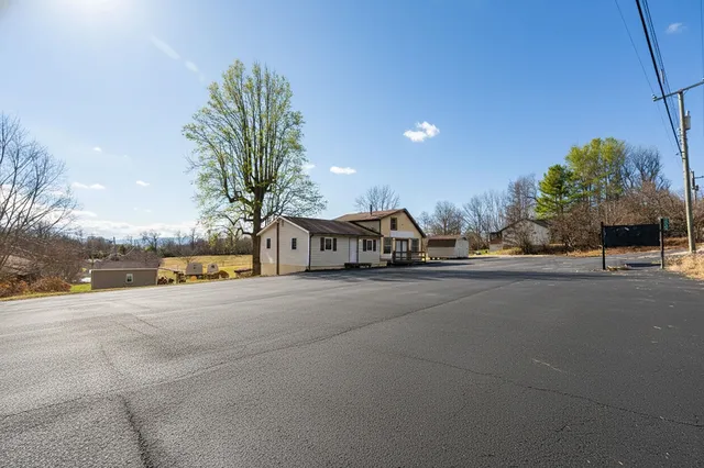 a view of a house with a yard and palm trees