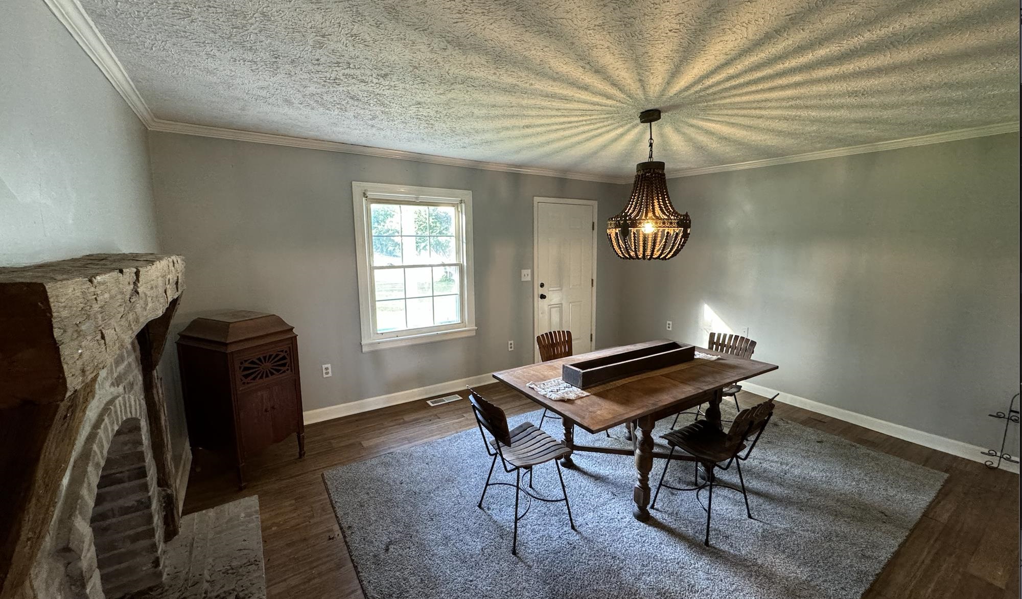 1336 Dunlap Orphanage Road Brighton, TN 38011 - Photo 11 of 14 Dining space featuring dark wood-type flooring, a stone fireplace, and ornamental molding