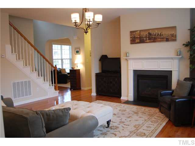 8413 Dunnington Circle Raleigh, NC 27613 - Photo 3 of 21 a living room with furniture a fireplace and a flat screen tv