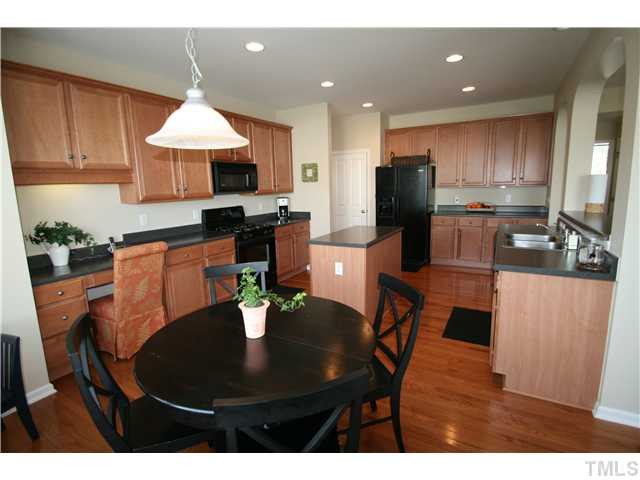 8413 Dunnington Circle Raleigh, NC 27613 - Photo 6 of 21 a kitchen with stainless steel appliances granite countertop a stove a refrigerator a kitchen island a stove a sink a dining table and chairs
