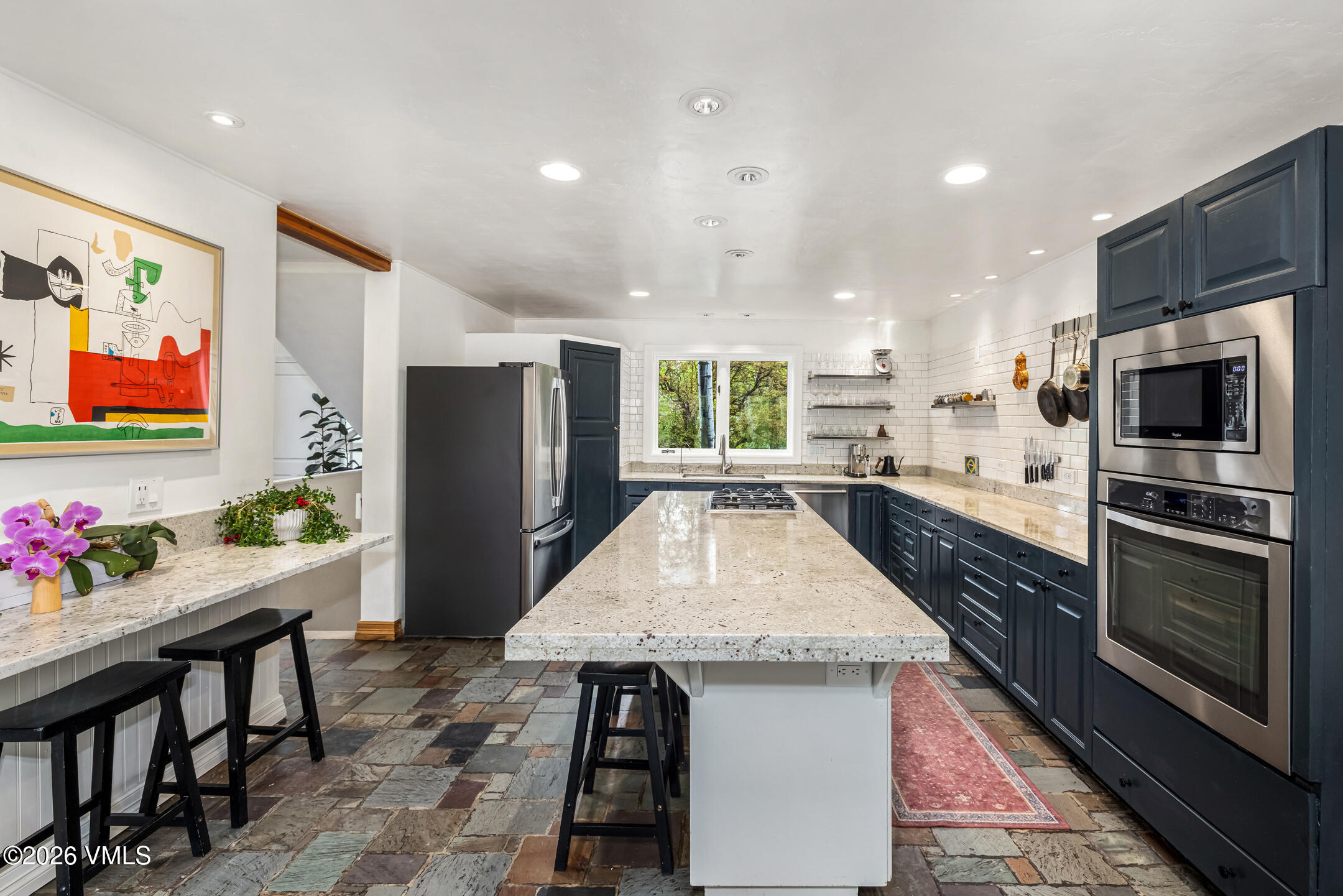 321 Meile Lane Edwards, CO 81632 - Photo 12 of 44 a kitchen with stainless steel appliances kitchen island granite countertop a table chairs in it and wooden floors