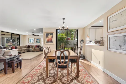 a living room with furniture floor to ceiling window and a flat screen tv