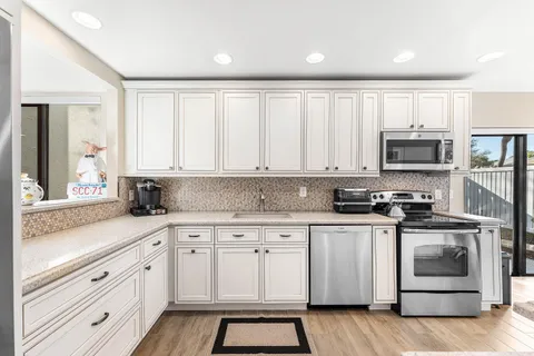 a kitchen with a table chairs stove and cabinets
