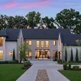 a front view of a house with a yard and trees
