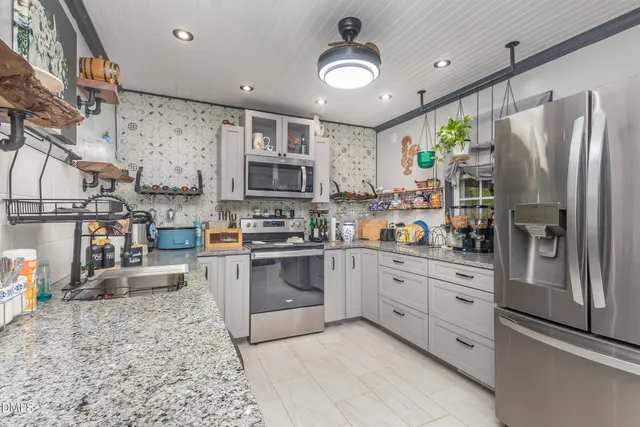 a kitchen with stainless steel appliances granite countertop a refrigerator sink and cabinets