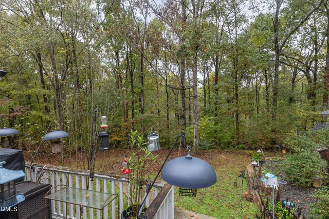 a view of deck with table and chairs a barbeque with wooden floor and fence