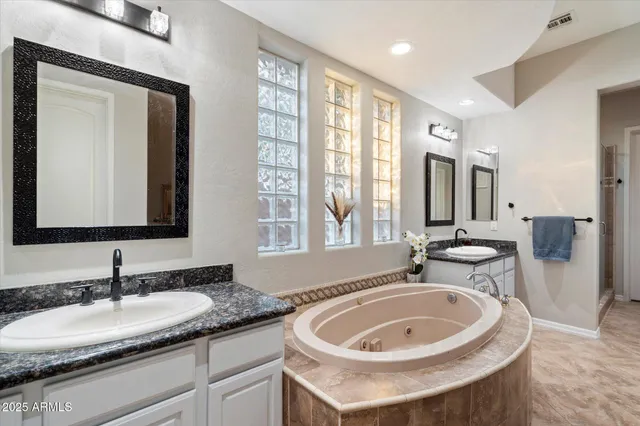 a bathroom with a tub sink and mirror