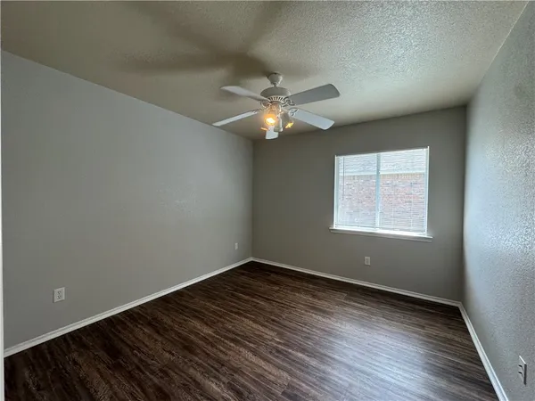an empty room with a window and a fan