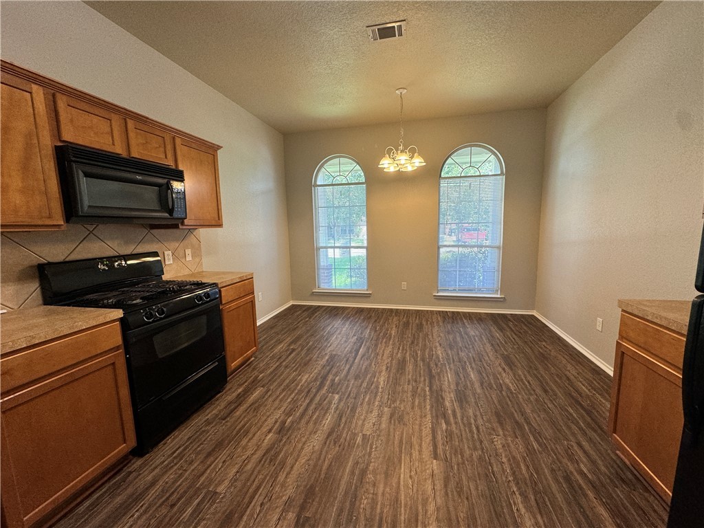 921 Whitewing Lane College Station, TX 77845 - Photo 4 of 14 a view of a kitchen stove and cabinets with wooden floor