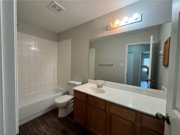 a bathroom with a tub a sink and a large mirror