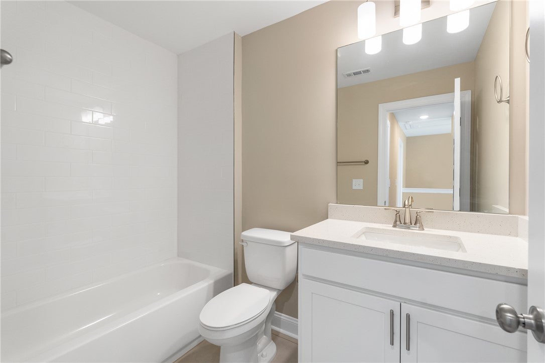 233 Black Swann Road Auburn, AL 36832 - Photo 11 of 26 This bathroom features a contemporary vanity with a sleek sink, complemented by a pristine bathtub and tiled shower.