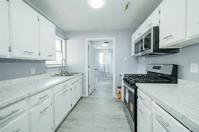 a kitchen with stainless steel appliances granite countertop a sink and a stove