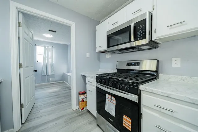 a kitchen with stainless steel appliances a stove a microwave and cabinets