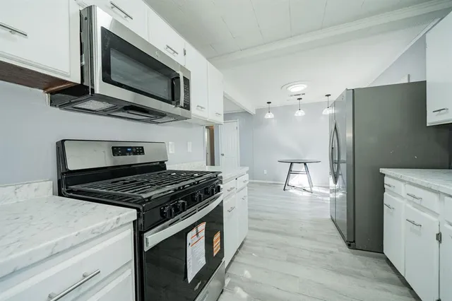 a kitchen with stainless steel appliances kitchen island granite countertop a stove and a microwave