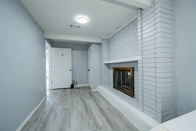 a view of a room with wooden floor and a fireplace