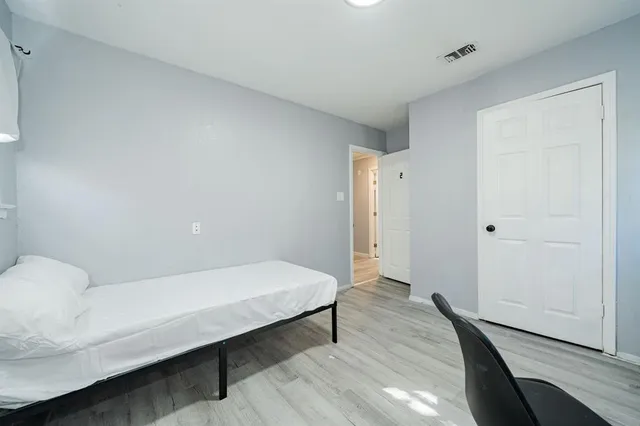 a bedroom with a bed and wooden floor