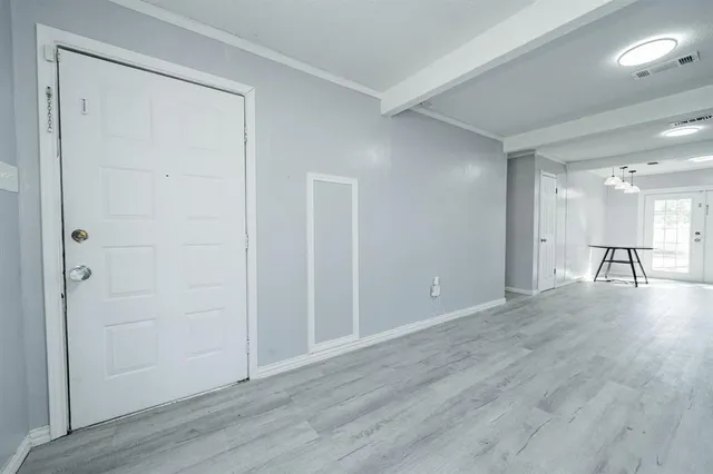 an empty room with wooden floor and a cabinet