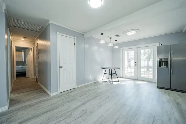 a view of a livingroom with wooden floor and a kitchen space