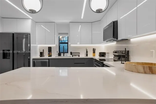 a kitchen with stainless steel appliances granite countertop a sink a stove and a refrigerator