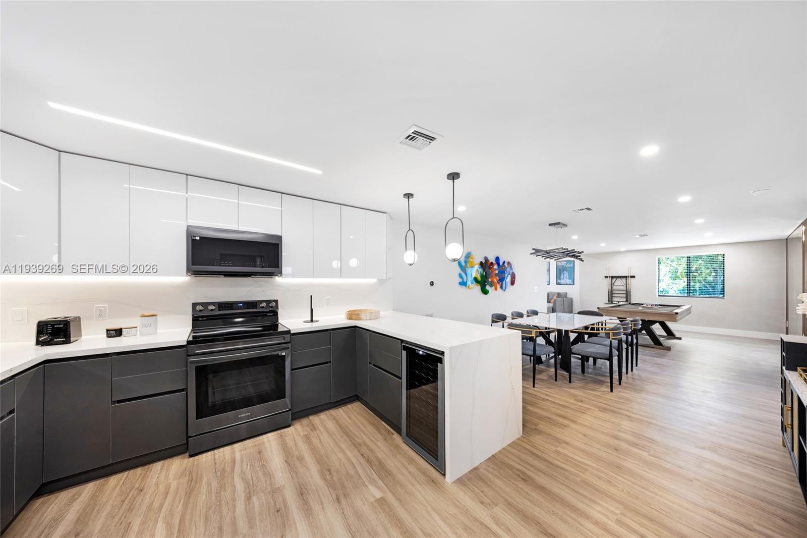 111 Northwest 53rd Street Miami, FL 33127 - Photo 15 of 53 a kitchen with stainless steel appliances granite countertop a sink dishwasher a stove and a refrigerator with wooden floor