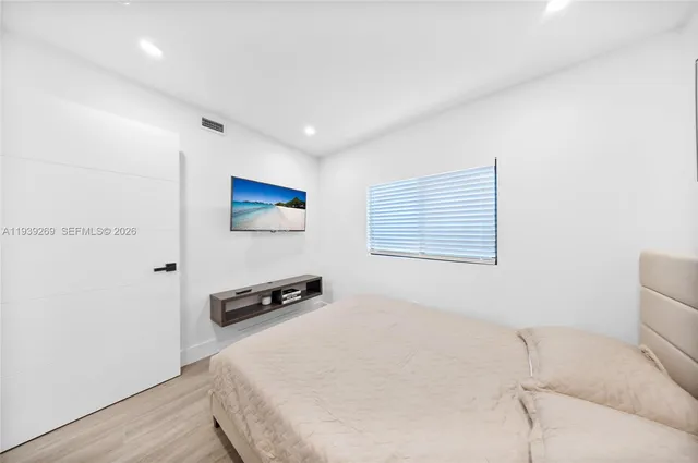 a hallway with a computer on a desk and wooden floor