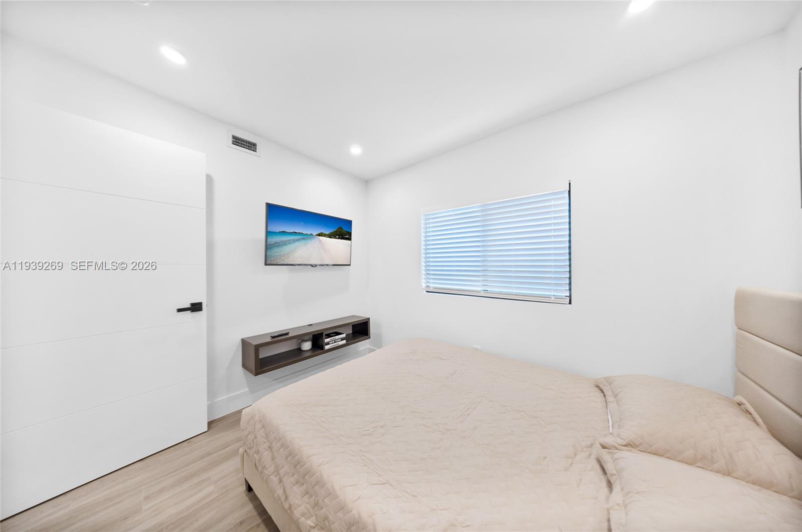 111 Northwest 53rd Street Miami, FL 33127 - Photo 23 of 53 a hallway with a computer on a desk and wooden floor