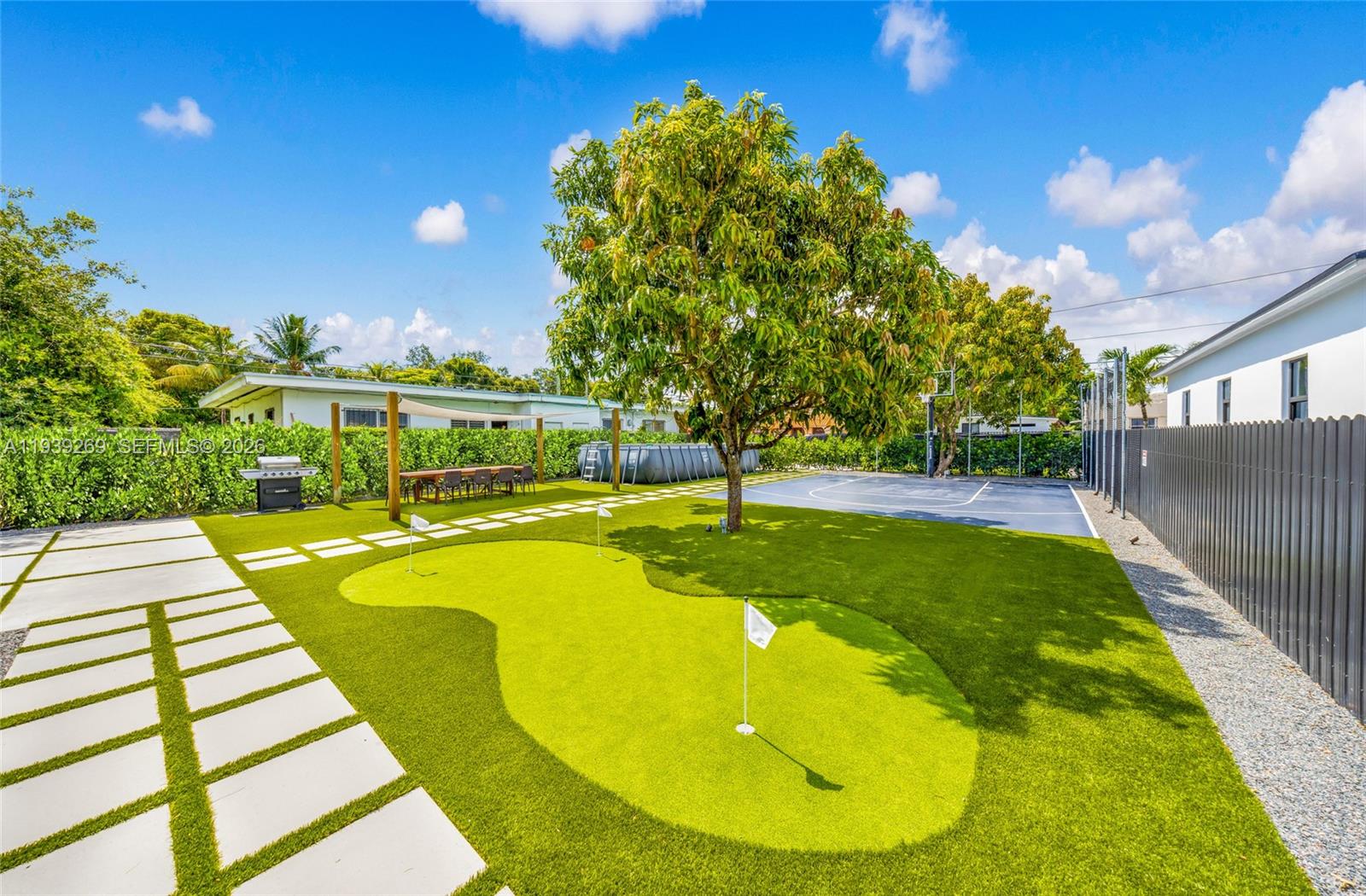 111 Northwest 53rd Street Miami, FL 33127 - Photo 49 of 53 a view of yard with swimming pool outdoor seating and trees in the background