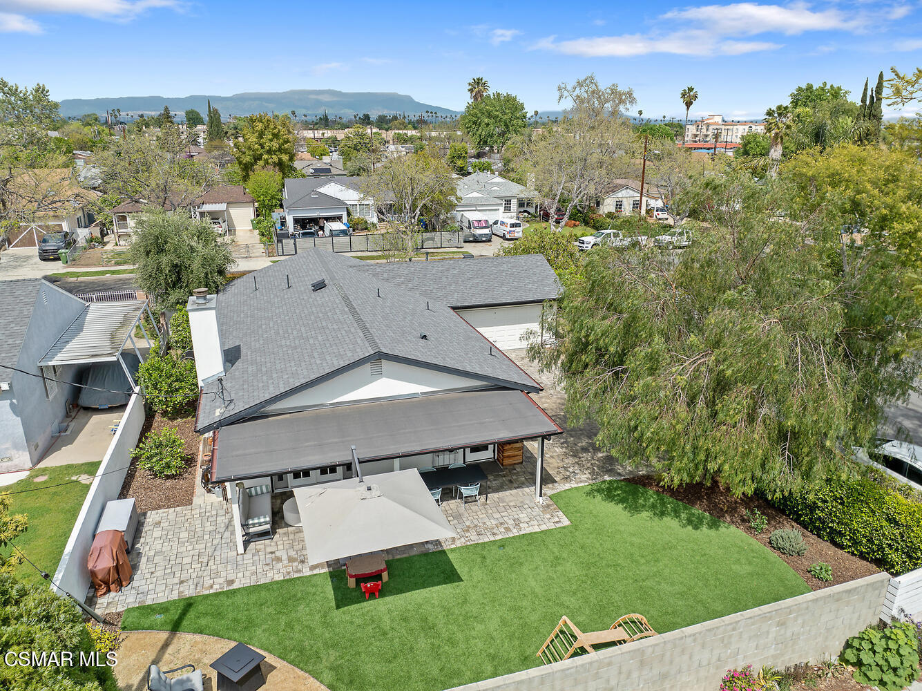 an aerial view of residential houses with outdoor space and trees