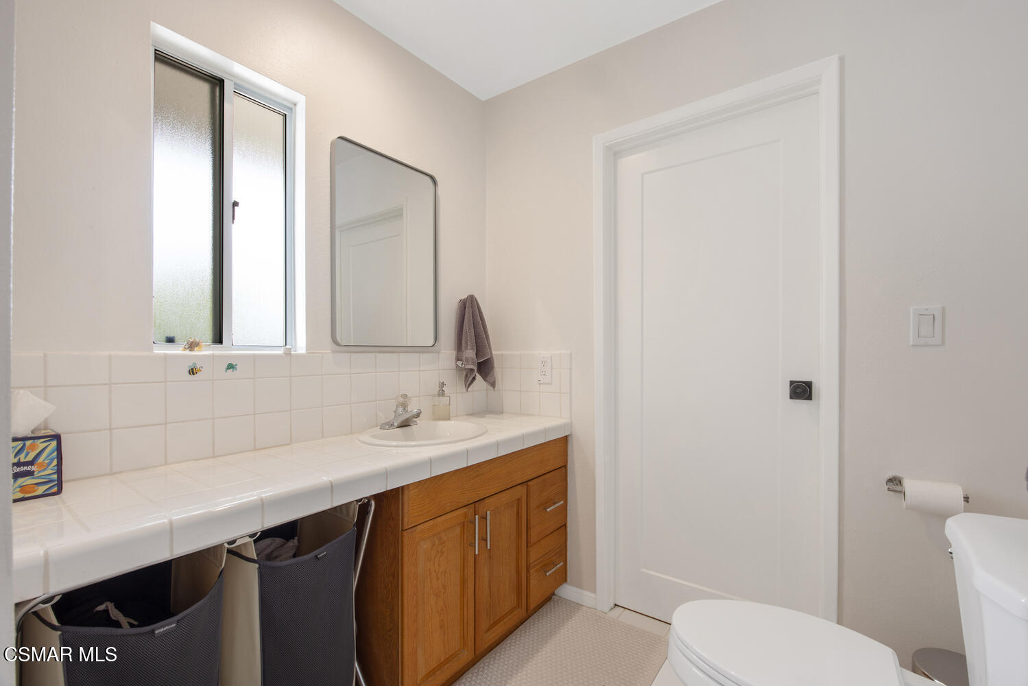 6657 Quartz Avenue Winnetka, CA 91306 - Photo 20 of 26 a bathroom with a toilet a sink a vanity and mirror