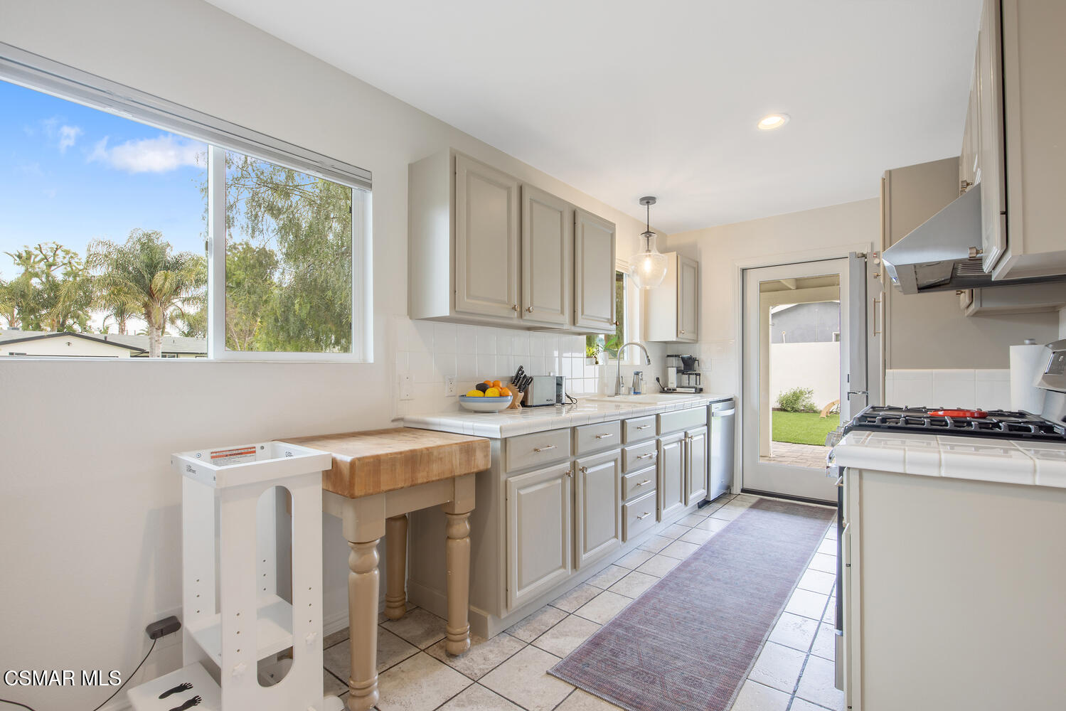6657 Quartz Avenue Winnetka, CA 91306 - Photo 10 of 26 a kitchen with a stove a sink and a refrigerator