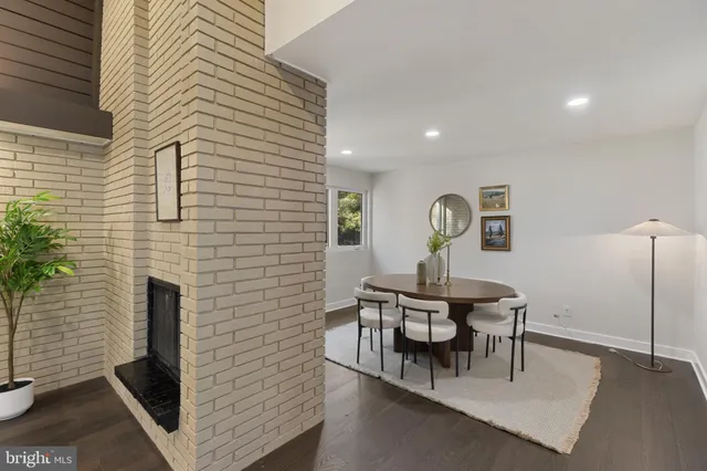 a living room with furniture a fireplace and a potted plant
