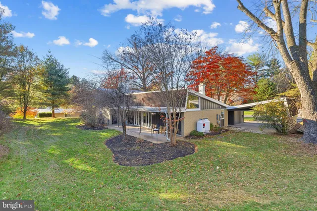 a view of a building with car parked on the road