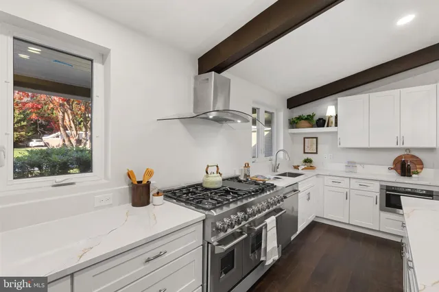 a kitchen with a stove a refrigerator and couches