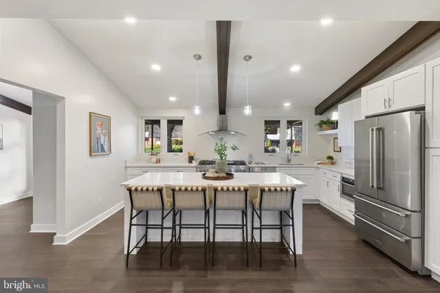 a kitchen with stainless steel appliances a table and chairs in it