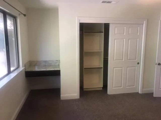 an empty room with windows and closet
