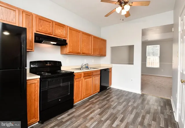 a kitchen with a sink a refrigerator a stove and wooden cabinets