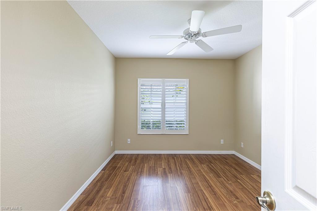 6914 Satinleaf Road North, Unit 102 Naples, FL 34109 - Photo 11 of 24 Spare room featuring dark wood-style flooring and ceiling fan