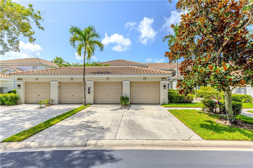 6914 Satinleaf Road North, Unit 102 Naples, FL 34109 - Photo 14 of 24 View of front of home featuring stucco siding, community garages, and a tiled roof