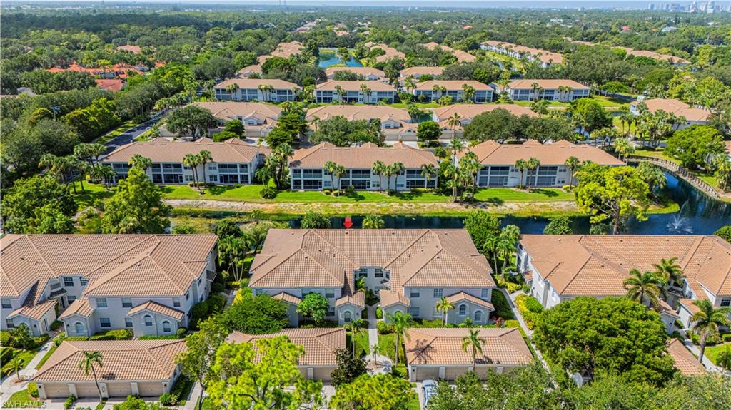 6914 Satinleaf Road North, Unit 102 Naples, FL 34109 - Photo 20 of 24 Aerial view of residential area with a nearby body of water