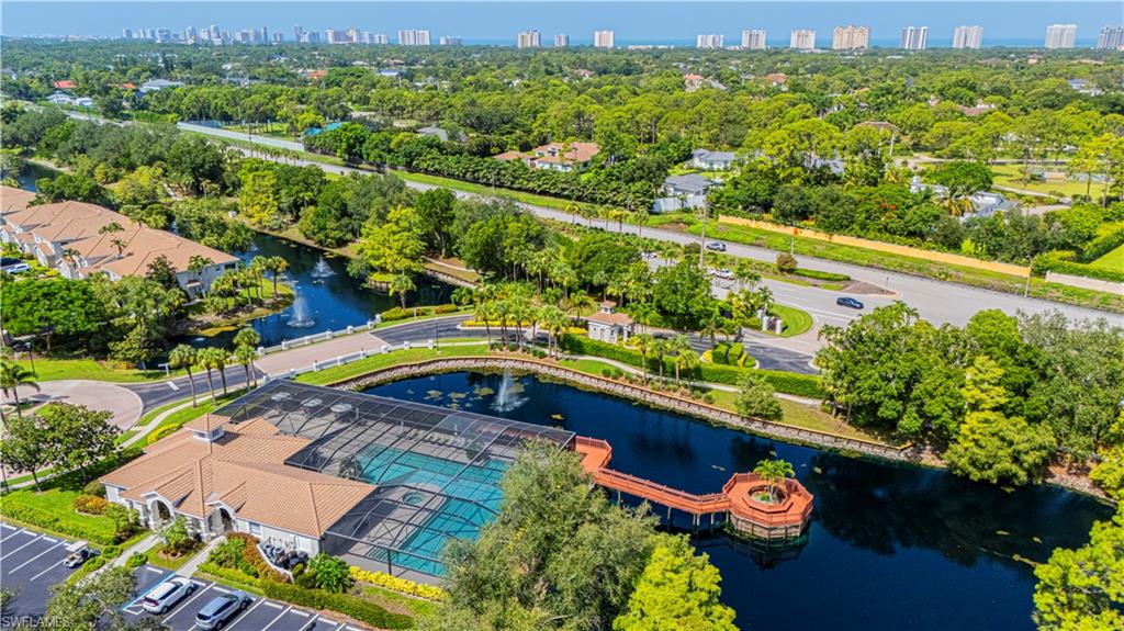 6914 Satinleaf Road North, Unit 102 Naples, FL 34109 - Photo 23 of 24 Drone / aerial view of city skyline and a tree filled landscape