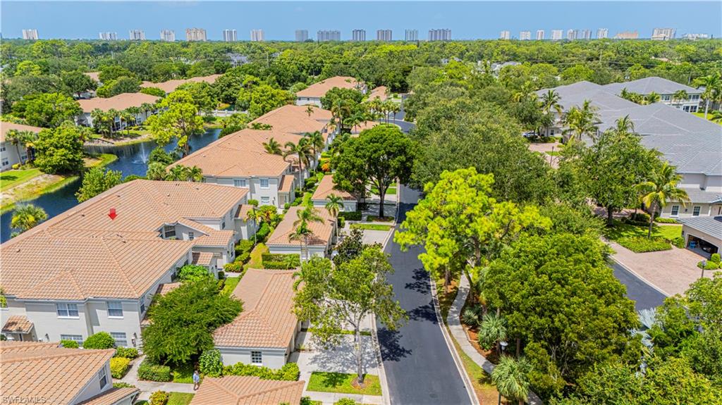 6914 Satinleaf Road North, Unit 102 Naples, FL 34109 - Photo 24 of 24 Aerial perspective of suburban area featuring city skyline and a tree filled landscape