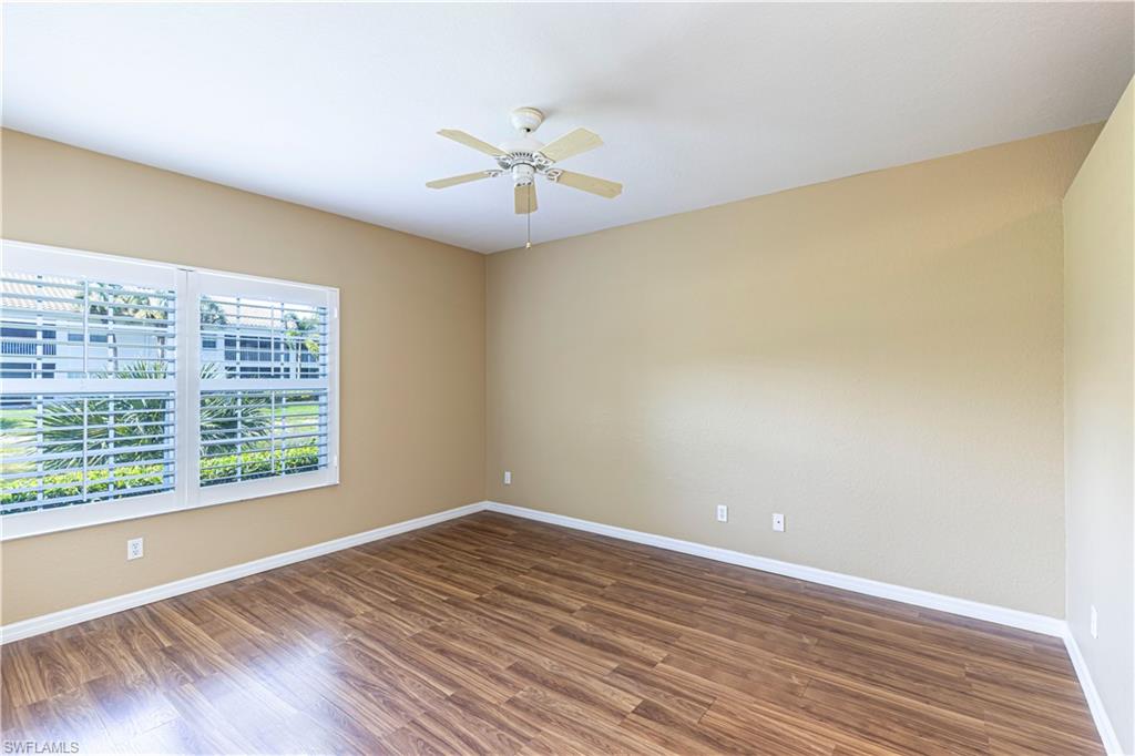 6914 Satinleaf Road North, Unit 102 Naples, FL 34109 - Photo 7 of 24 Spare room with ceiling fan and wood finished floors