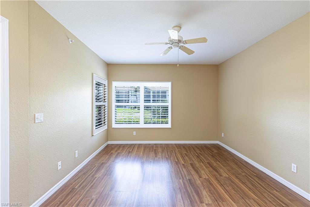 6914 Satinleaf Road North, Unit 102 Naples, FL 34109 - Photo 8 of 24 Empty room with a ceiling fan, wood finished floors, a textured wall, and a textured ceiling