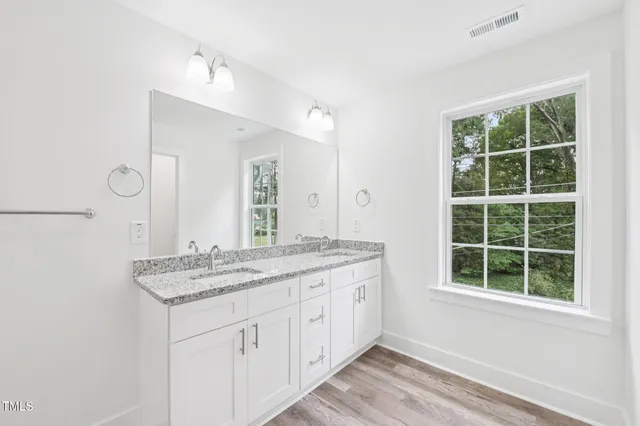 a bathroom with a granite countertop sink and a window