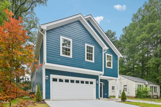 a front view of a house with a tree