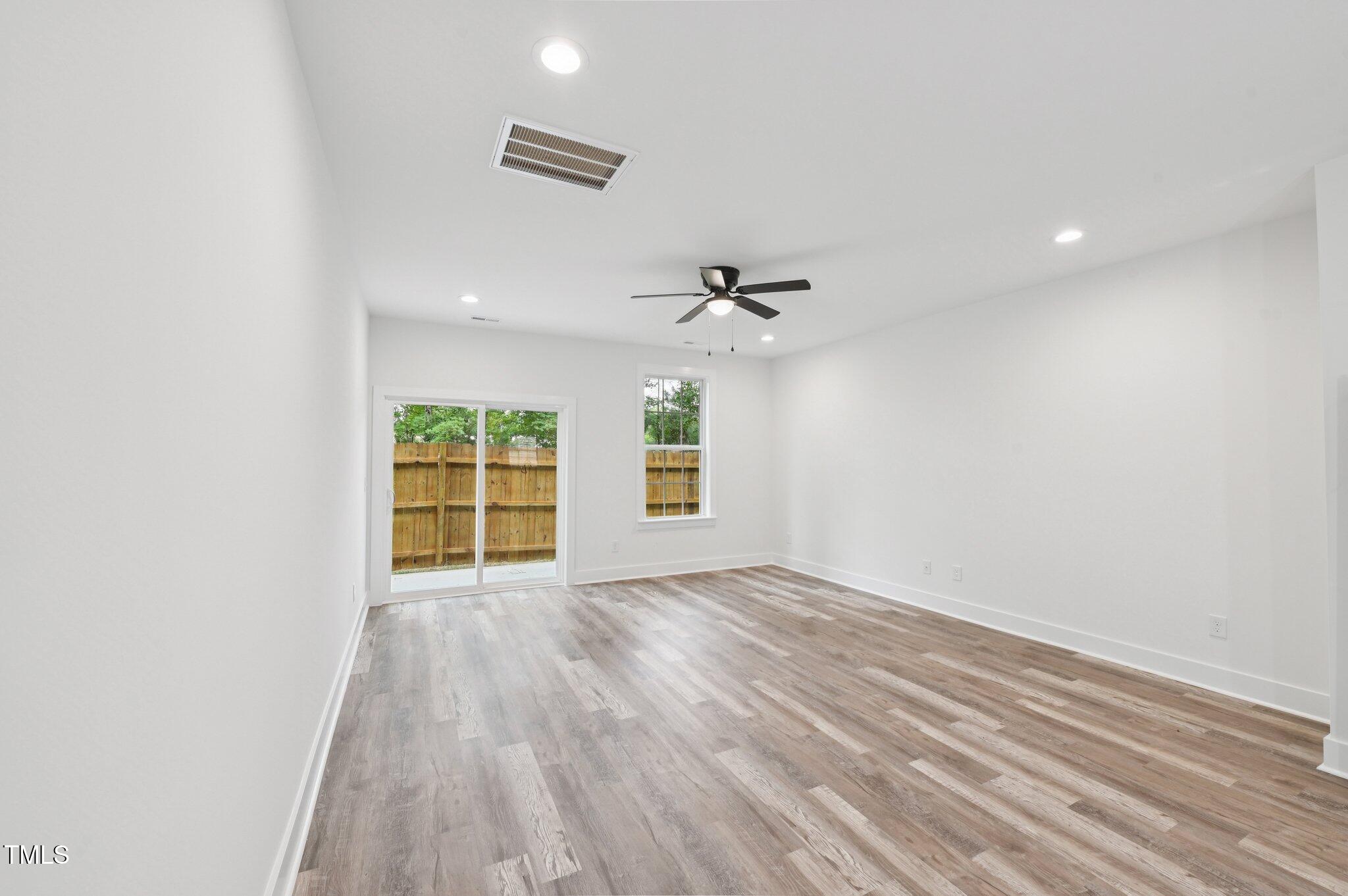 2607 Duke Homestead Road, Unit A Durham, NC 27705 - Photo 6 of 27 wooden floor in an empty room with a window