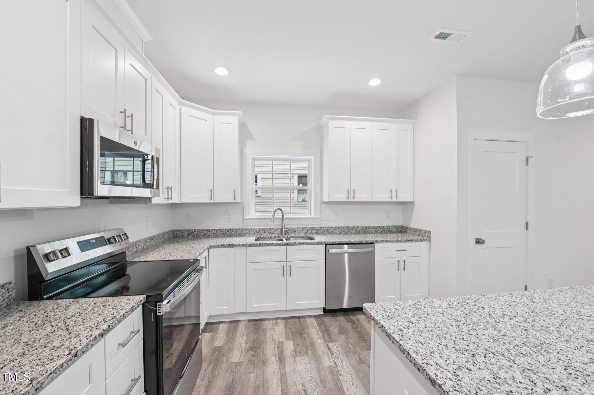2607 Duke Homestead Road, Unit A Durham, NC 27705 - Photo 9 of 27 a kitchen with a sink stove and cabinets