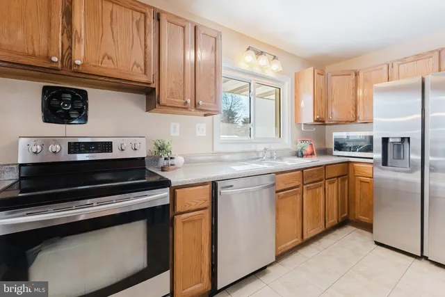 a kitchen with stainless steel appliances granite countertop a refrigerator sink and cabinets
