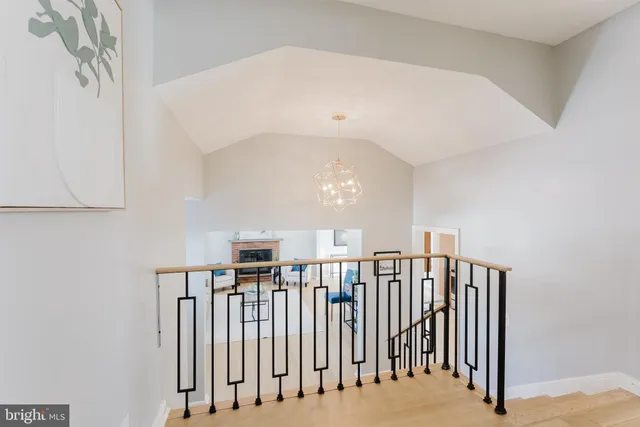 a view of staircase with railing and a chandelier