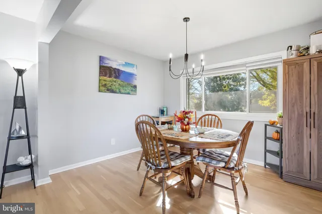 a dining room with furniture a chandelier and wooden floor